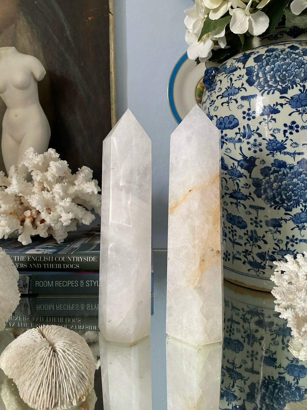 Two crystal obelisks on a surface with decorative items including a vase and books, available  to buy on the-salon.com. SALON curates the finest , unique, handmade pieces from the interior industry's best makers and brands. Shop luxury furniture, lighting, rugs, art, antiques and vintage pieces and accessories from SALON interior designed rooms.