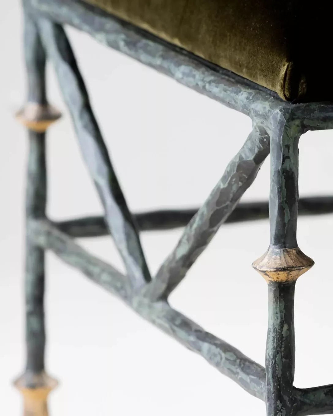 Close-up of a metal end bench with a cushioned seat on a white background, available  to buy on the-salon.com. SALON curates the finest , unique, handmade pieces from the interior industry's best makers and brands. Shop luxury furniture, lighting, rugs, art, antiques and vintage pieces and accessories from SALON interior designed rooms.
