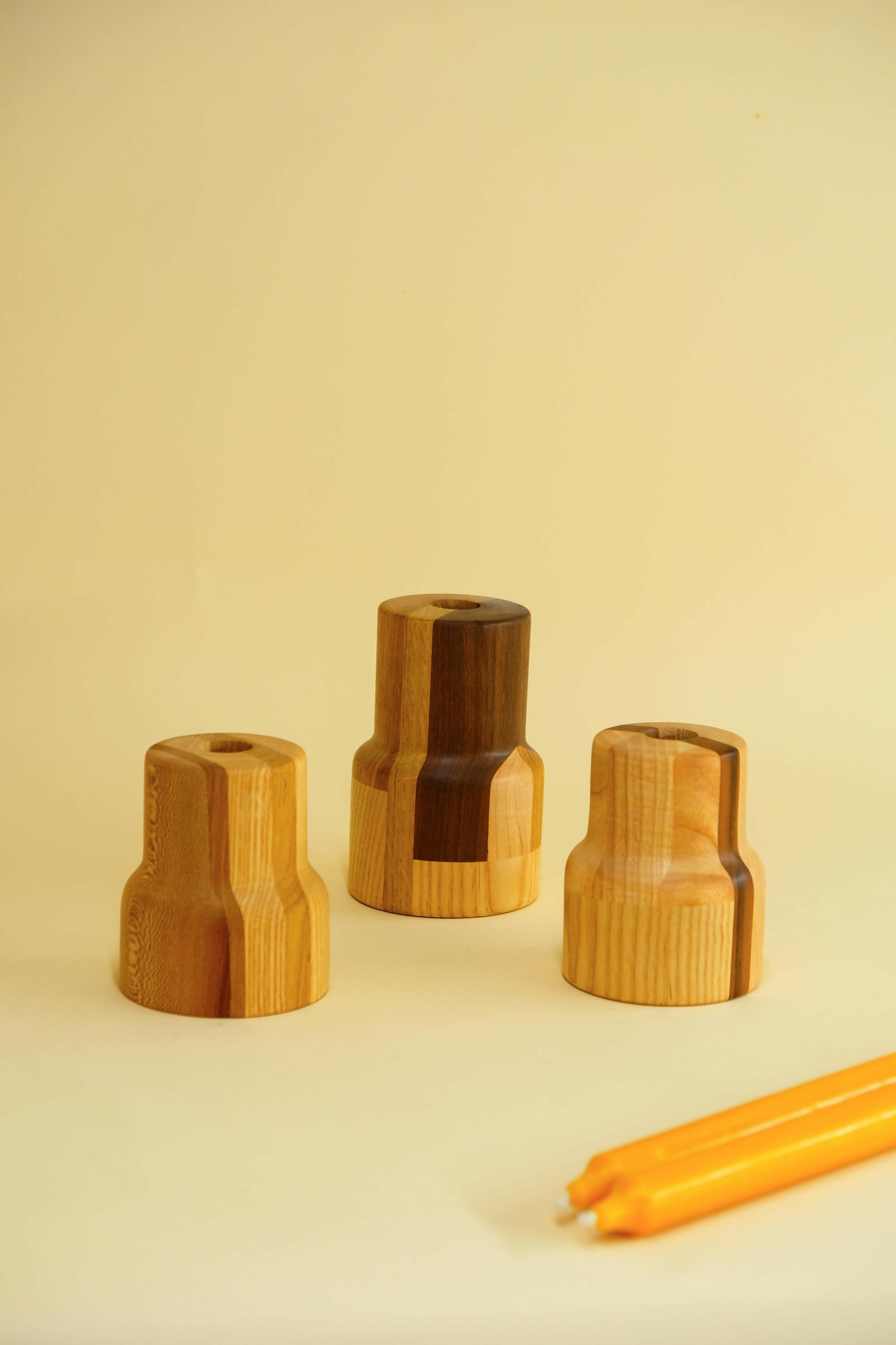 Three wooden candle holders on a beige background- available  to buy on the-salon.com. SALON curates the finest , unique, handmade pieces from the interior industry's best makers and brands. Shop luxury furniture, lighting, rugs, art, antiques and vintage pieces and accessories from SALON interior designed rooms.