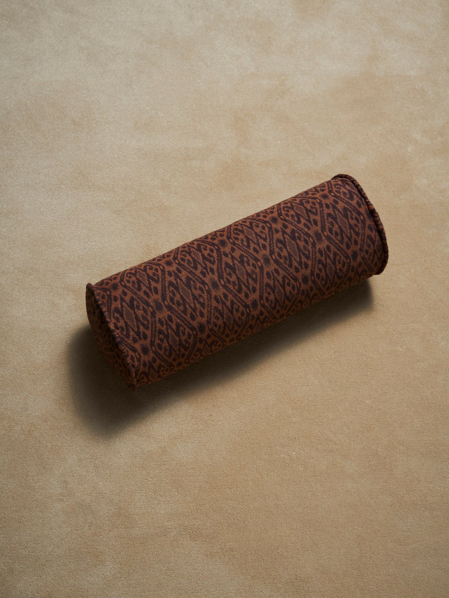 Brown cylindrical pillow with a leopard print pattern on a beige background,  available  to buy on the-salon.com. SALON curates the finest , unique, handmade pieces from the interior industry's best makers and brands. Shop luxury furniture, lighting, rugs, art, antiques and vintage pieces and accessories from SALON interior designed rooms.