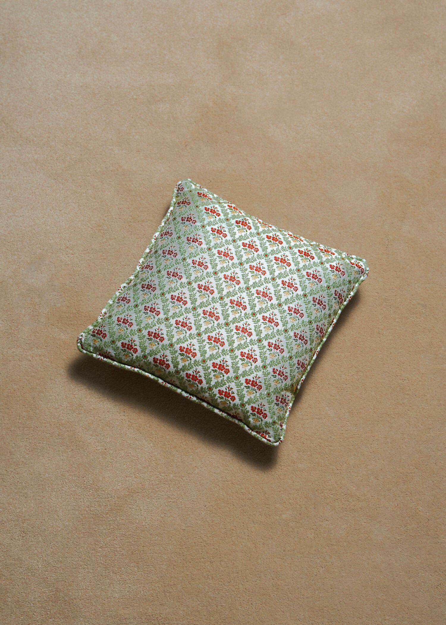 Green patterned pillow on a brown background,  available  to buy on the-salon.com. SALON curates the finest , unique, handmade pieces from the interior industry's best makers and brands. Shop luxury furniture, lighting, rugs, art, antiques and vintage pieces and accessories from SALON interior designed rooms.