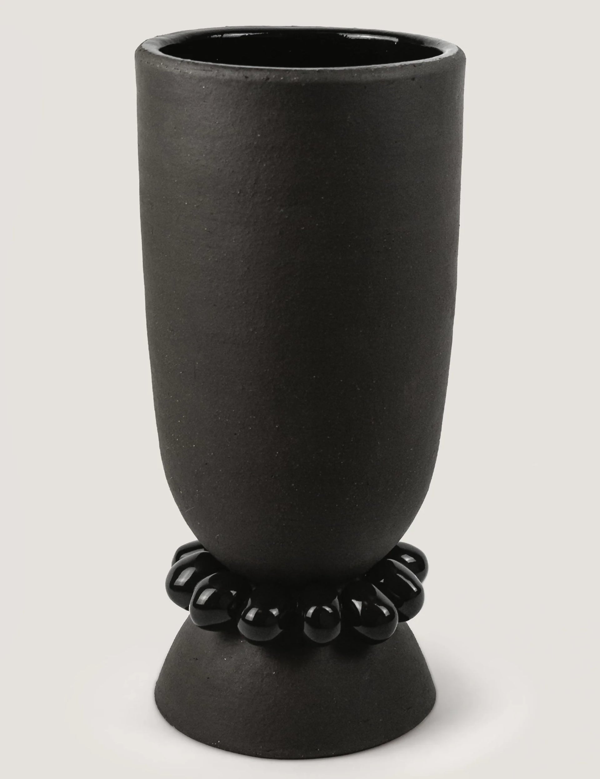 Black ceramic vase with decorative beads on a light gray background, available  to buy on the-salon.com. SALON curates the finest , unique, handmade pieces from the interior industry's best makers and brands. Shop luxury furniture, lighting, rugs, art, antiques and vintage pieces and accessories from SALON interior designed rooms.