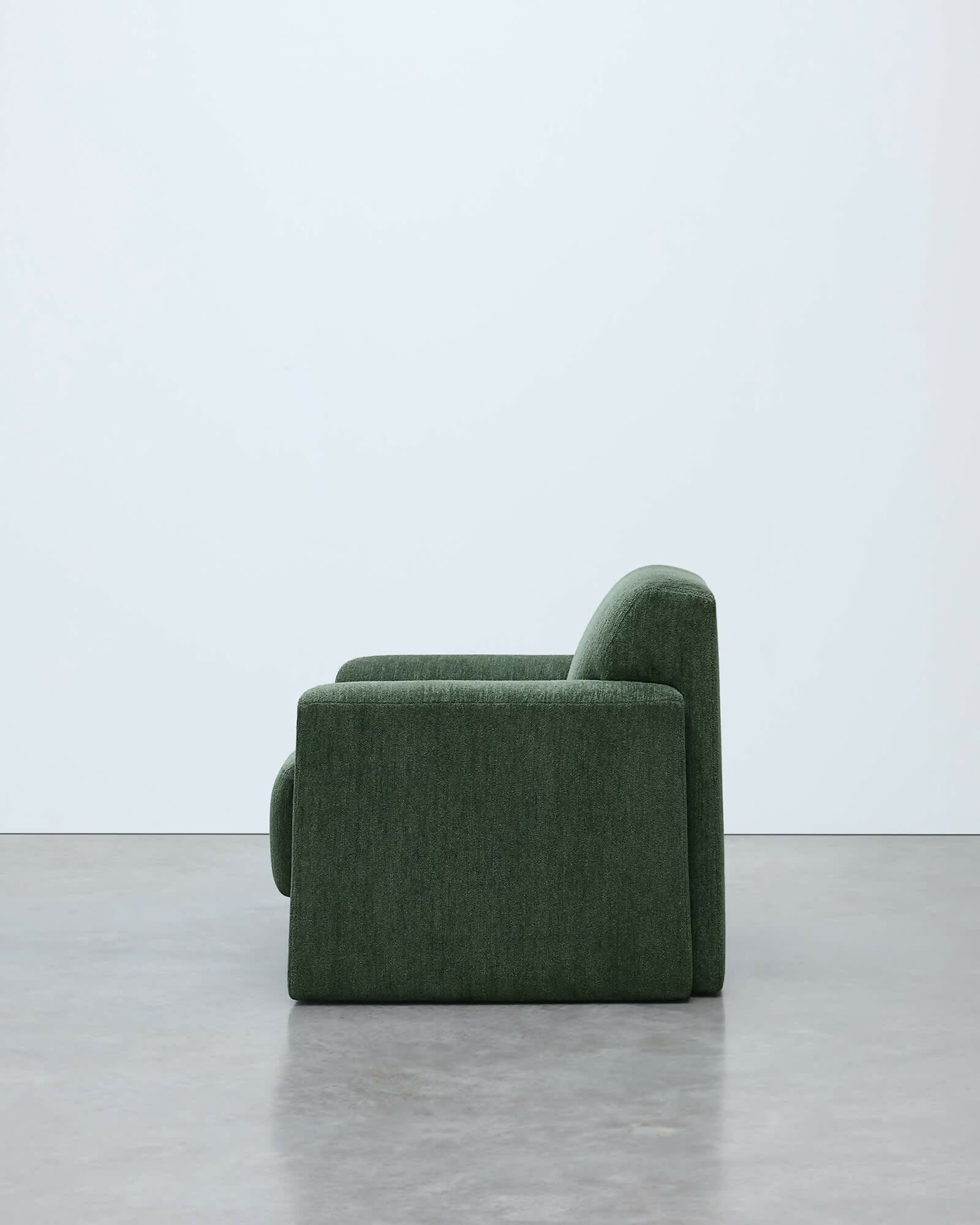 Green sofa on a gray floor with a white background, available  to buy on the-salon.com. SALON curates the finest , unique, handmade pieces from the interior industry's best makers and brands. Shop luxury furniture, lighting, rugs, art, antiques and vintage pieces and accessories from SALON interior designed rooms.