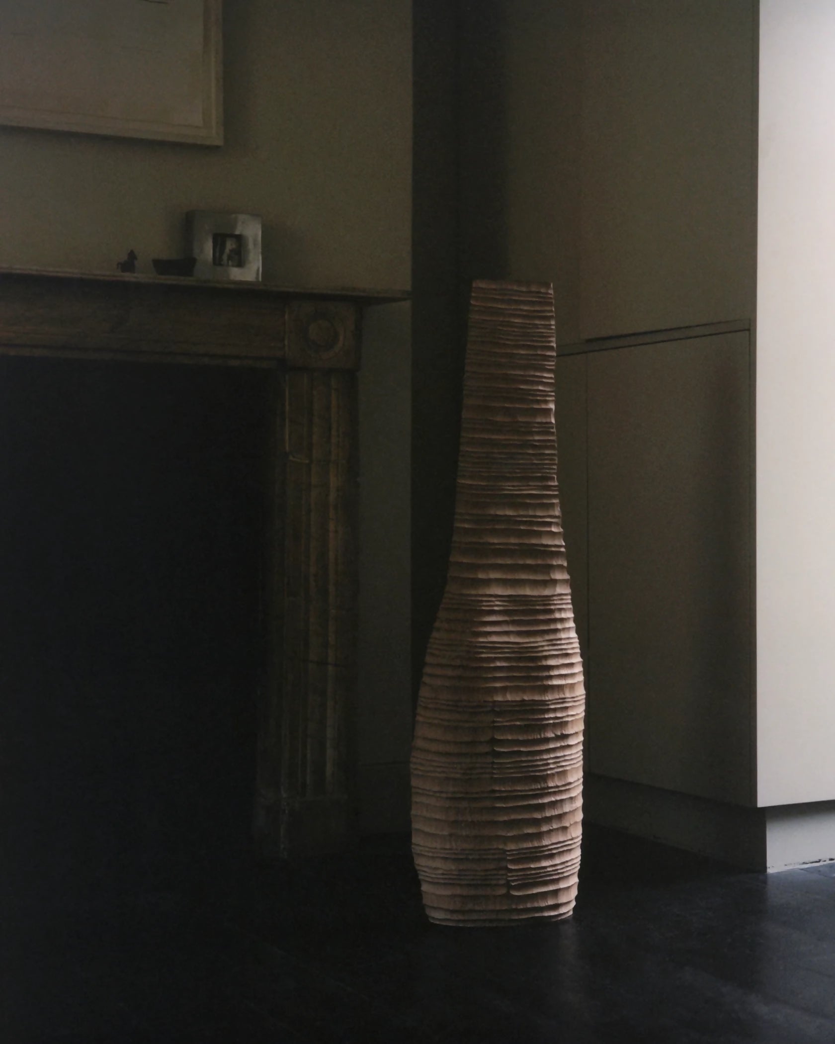 Tall, textured vase in a dimly lit room with a fireplace- available  to buy on the-salon.com. SALON curates the finest , unique, handmade pieces from the interior industry's best makers and brands. Shop luxury furniture, lighting, rugs, art, antiques and vintage pieces and accessories from SALON interior designed rooms.