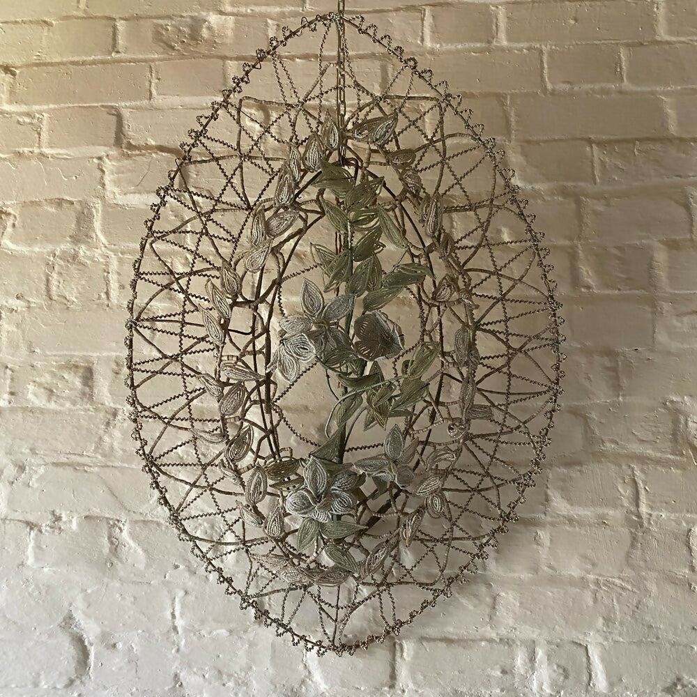 Decorative wall hanging with floral design against a brick wall,  available  to buy on the-salon.com. SALON curates the finest , unique, handmade pieces from the interior industry's best makers and brands. Shop luxury furniture, lighting, rugs, art, antiques and vintage pieces and accessories from SALON interior designed rooms.