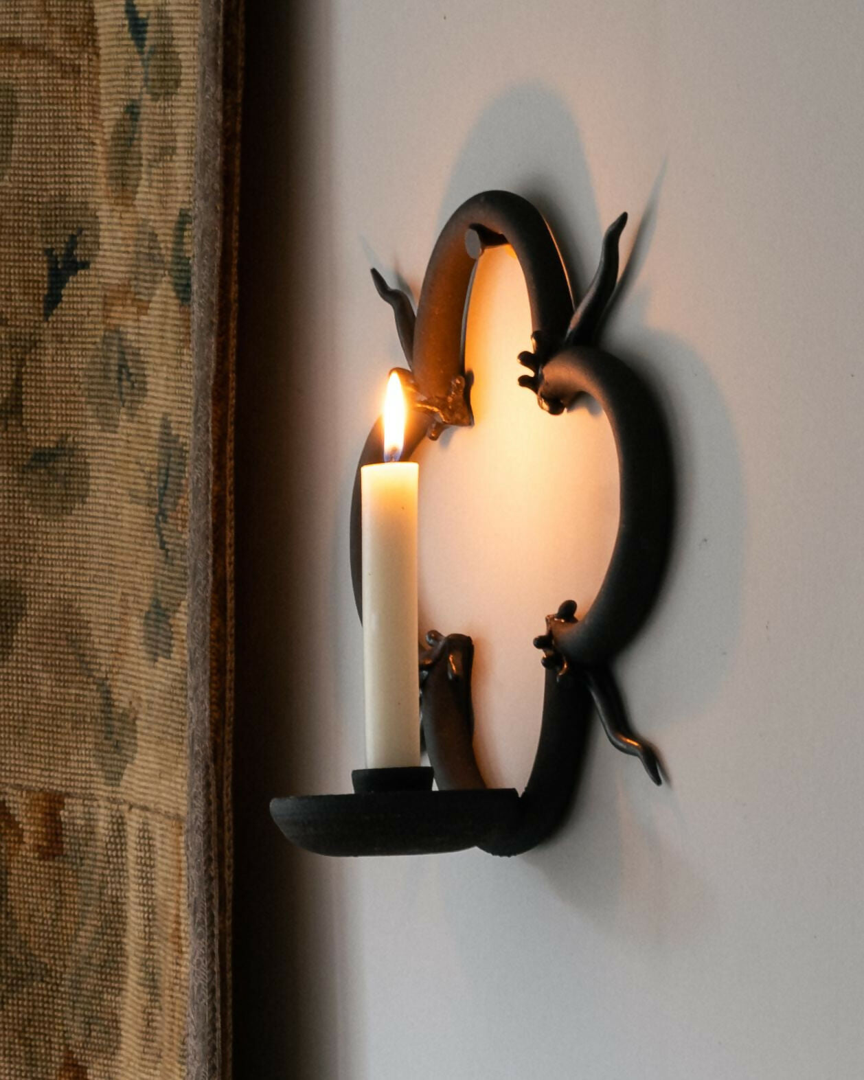 Decorative wall sconce with a candle on a white wall,  available  to buy on the-salon.com. SALON curates the finest , unique, handmade pieces from the interior industry's best makers and brands. Shop luxury furniture, lighting, rugs, art, antiques and vintage pieces and accessories from SALON interior designed rooms.