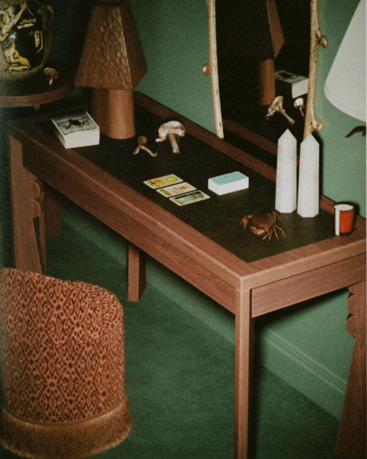 Wooden table with various items on a green wall background