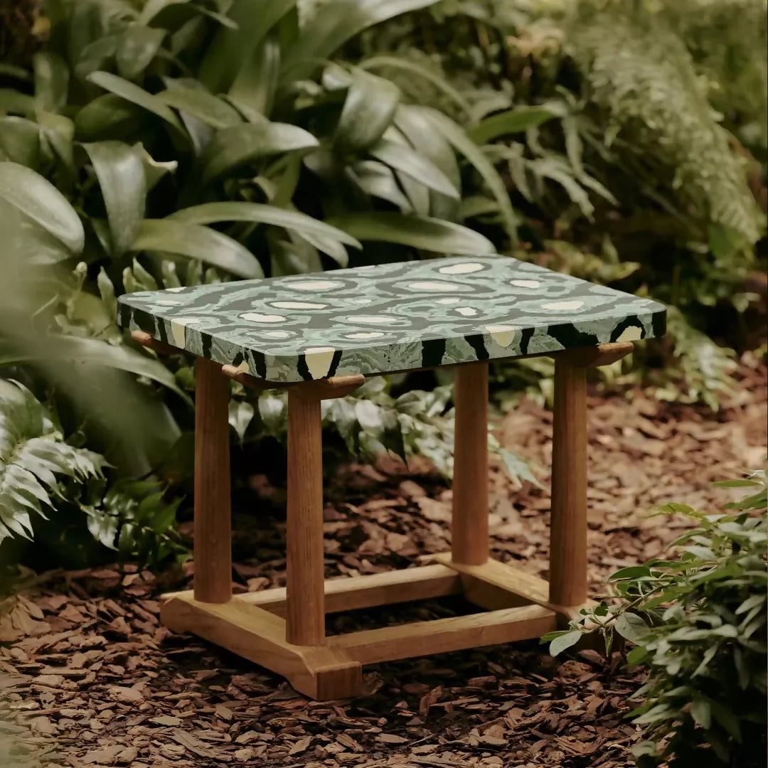 Small wooden table with a green marble top in a garden setting,  available  to buy on the-salon.com. SALON curates the finest , unique, handmade pieces from the interior industry's best makers and brands. Shop luxury furniture, lighting, rugs, art, antiques and vintage pieces and accessories from SALON interior designed rooms.