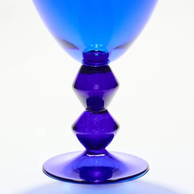 Blue glass vase with a unique design on a white background,  available  to buy on the-salon.com. SALON curates the finest , unique, handmade pieces from the interior industry's best makers and brands. Shop luxury furniture, lighting, rugs, art, antiques and vintage pieces and accessories from SALON interior designed rooms.