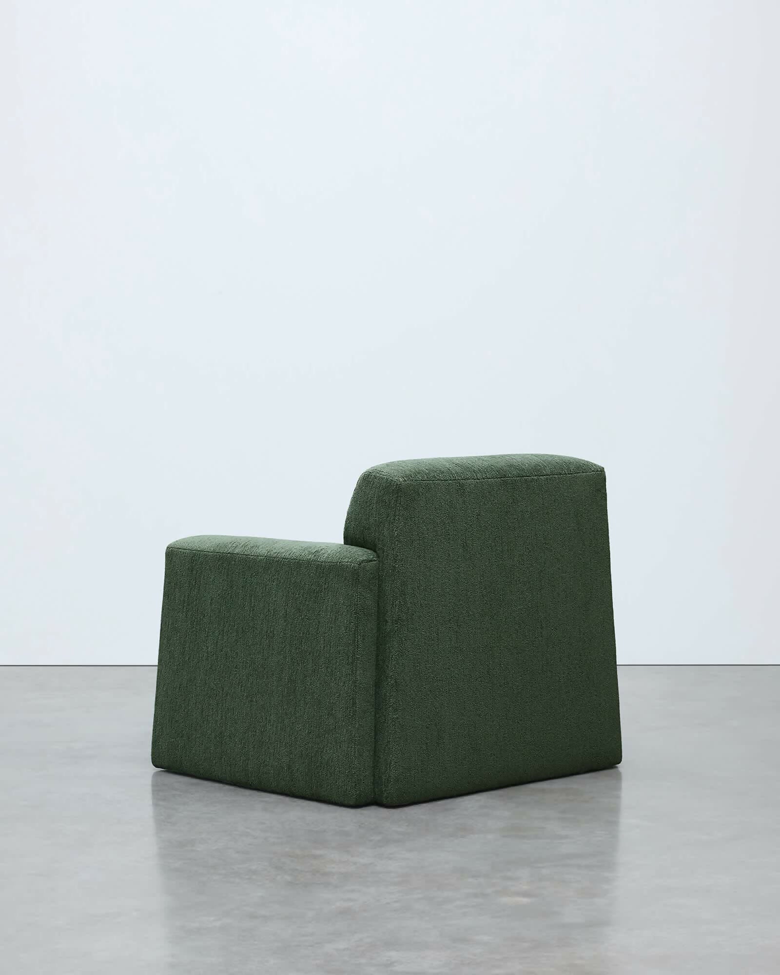 Green modular chair on a light gray floor with a white background, available  to buy on the-salon.com. SALON curates the finest , unique, handmade pieces from the interior industry's best makers and brands. Shop luxury furniture, lighting, rugs, art, antiques and vintage pieces and accessories from SALON interior designed rooms.