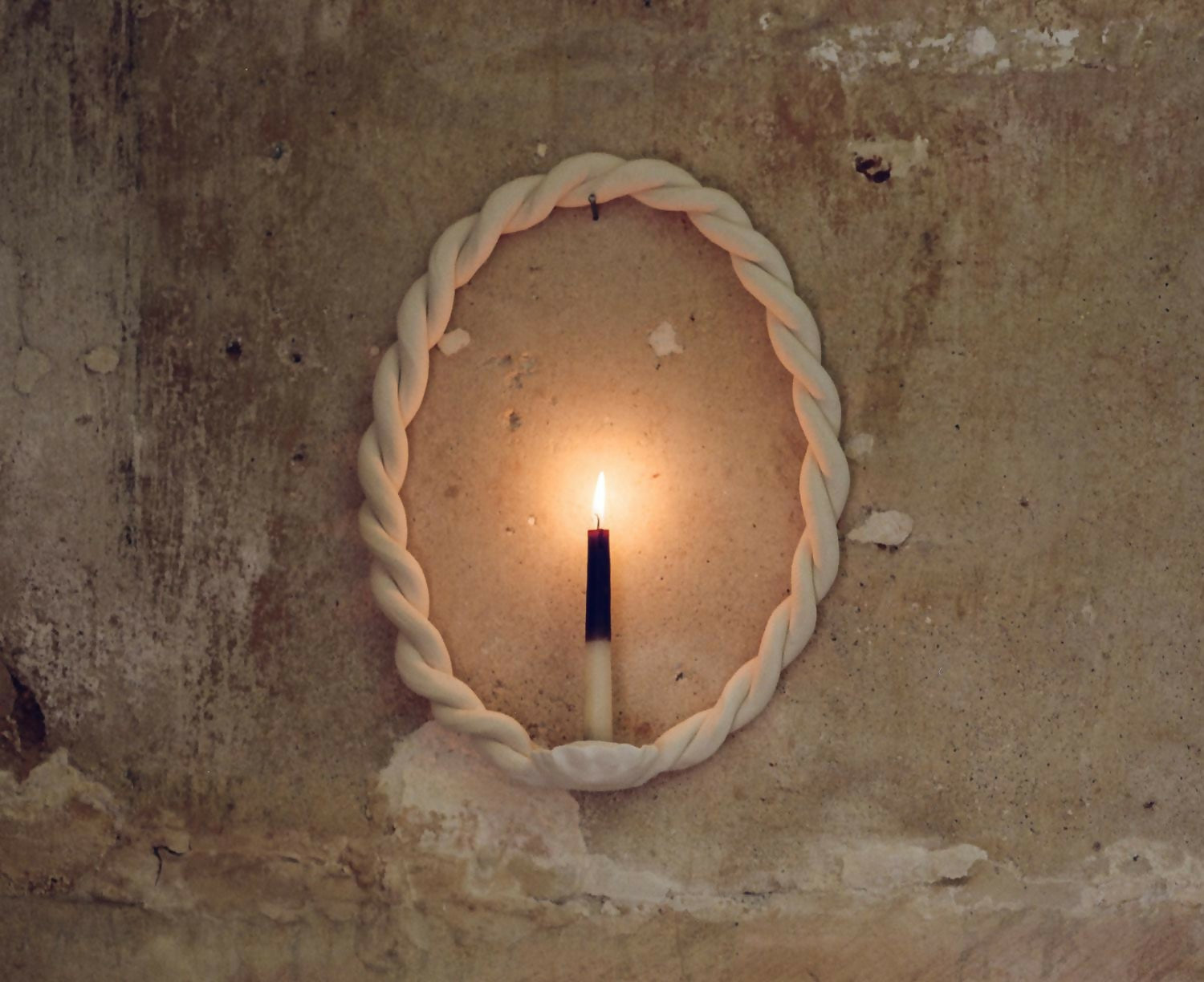 Candle inside a circular, rope-like frame on a textured wall,  available  to buy on the-salon.com. SALON curates the finest , unique, handmade pieces from the interior industry's best makers and brands. Shop luxury furniture, lighting, rugs, art, antiques and vintage pieces and accessories from SALON interior designed rooms.