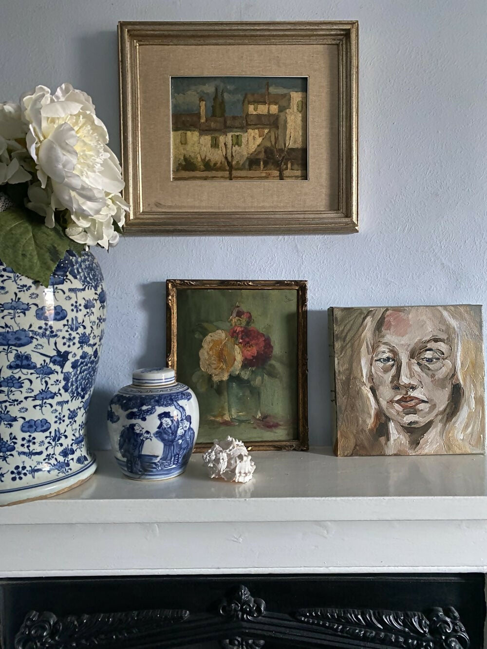 Decorative shelf with vases, a framed painting, and a portrait against a light blue wall,  available  to buy on the-salon.com. SALON curates the finest , unique, handmade pieces from the interior industry's best makers and brands. Shop luxury furniture, lighting, rugs, art, antiques and vintage pieces and accessories from SALON interior designed rooms.