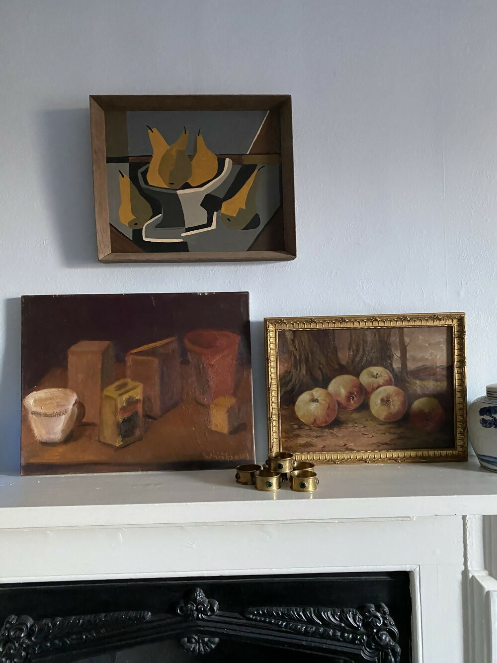Three framed still life paintings on a white mantelpiece against a gray wall, available  to buy on the-salon.com. SALON curates the finest , unique, handmade pieces from the interior industry's best makers and brands. Shop luxury furniture, lighting, rugs, art, antiques and vintage pieces and accessories from SALON interior designed rooms.