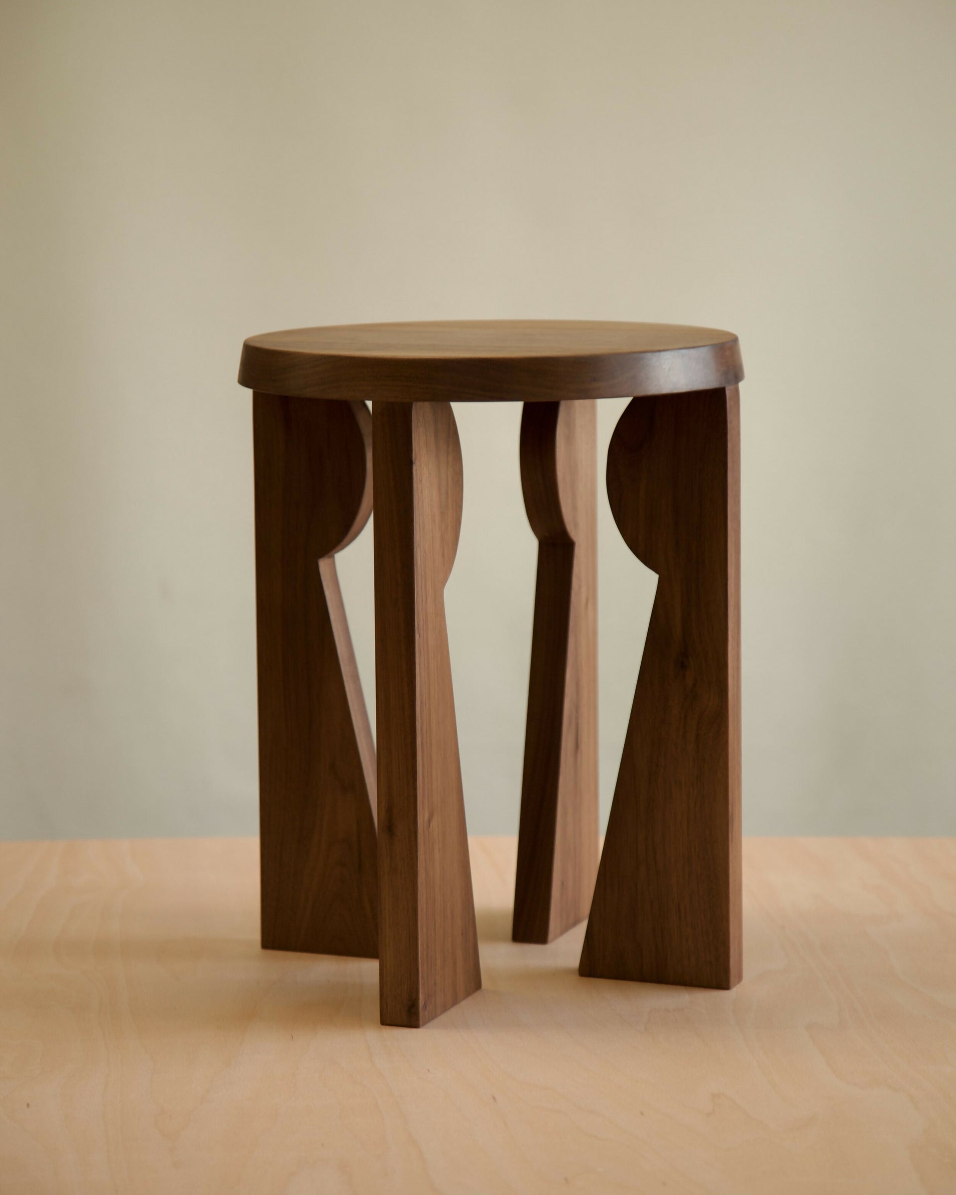 Wooden side table with unique design on a beige background,  available  to buy on the-salon.com. SALON curates the finest , unique, handmade pieces from the interior industry's best makers and brands. Shop luxury furniture, lighting, rugs, art, antiques and vintage pieces and accessories from SALON interior designed rooms.