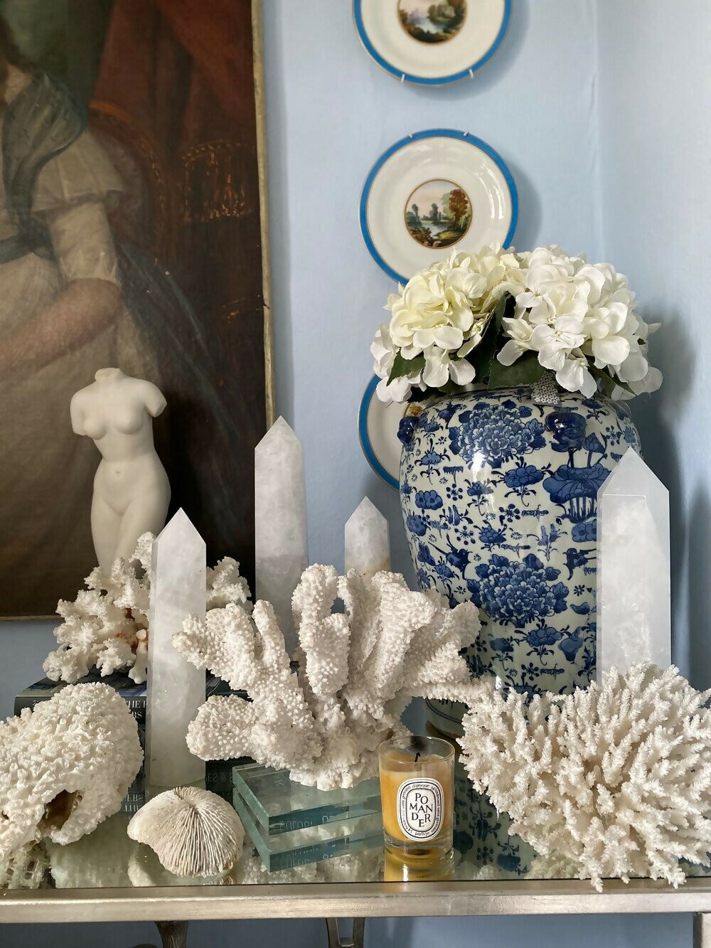 Decorative table setting with Crystal Towers, corals, candles, and a blue and white vase against a wall with framed pictures, available  to buy on the-salon.com. SALON curates the finest , unique, handmade pieces from the interior industry's best makers and brands. Shop luxury furniture, lighting, rugs, art, antiques and vintage pieces and accessories from SALON interior designed rooms.