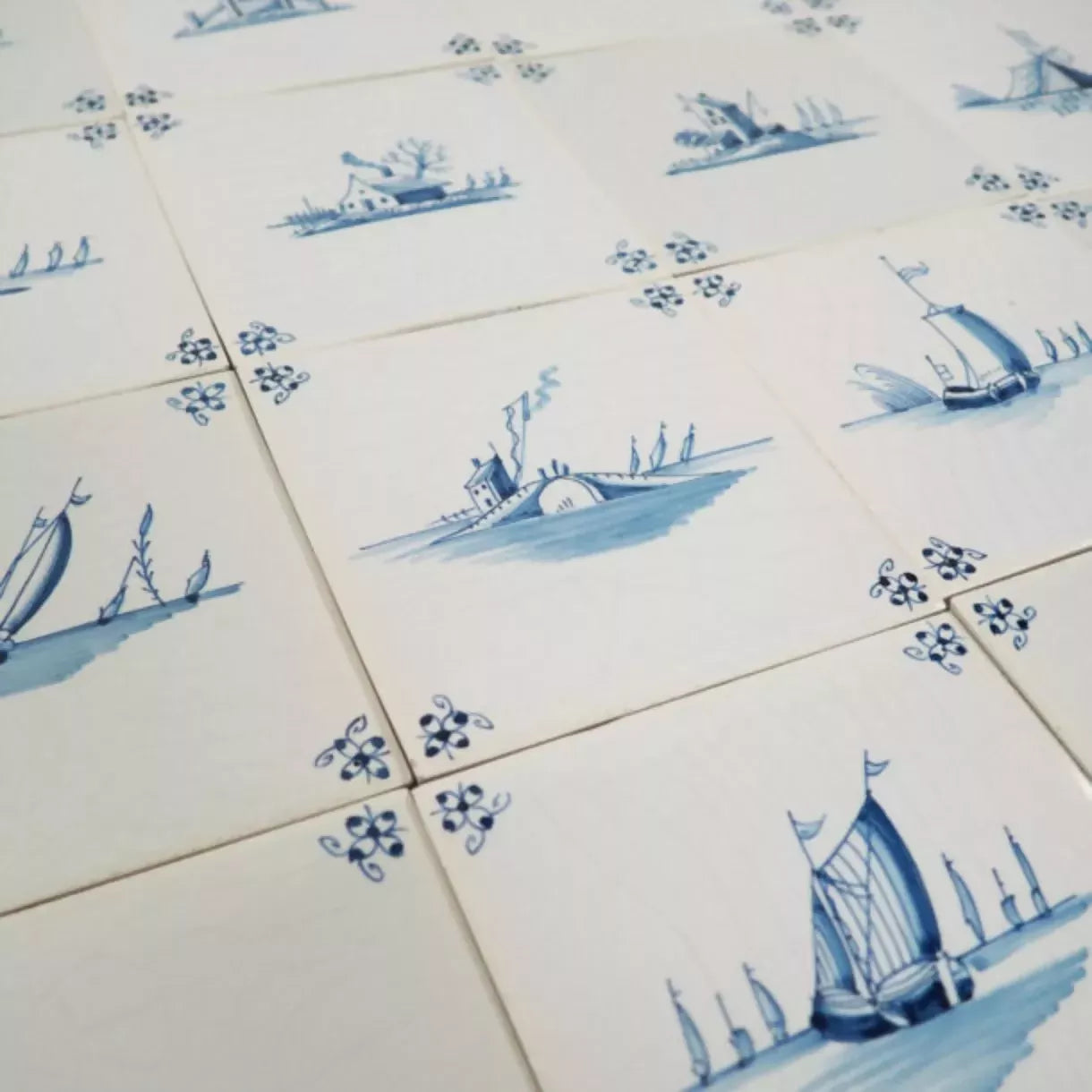 Pattern of blue ship and windmill designs on white tiles,  available  to buy on the-salon.com. SALON curates the finest , unique, handmade pieces from the interior industry's best makers and brands. Shop luxury furniture, lighting, rugs, art, antiques and vintage pieces and accessories from SALON interior designed rooms.