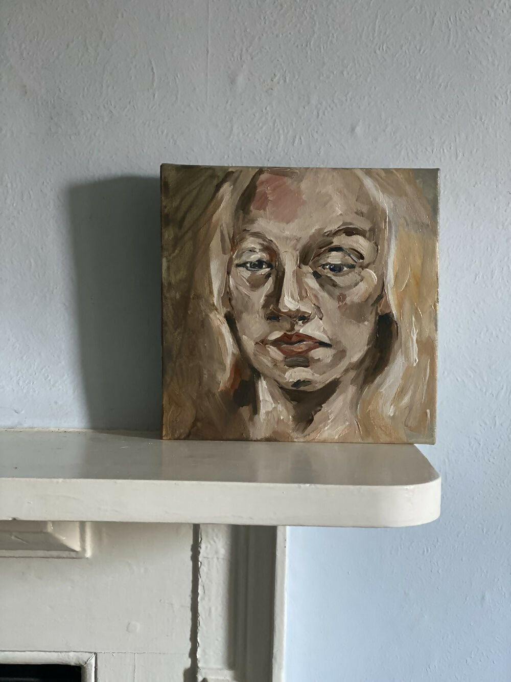 Portrait painting of a woman on a white shelf against a light blue wall,  available  to buy on the-salon.com. SALON curates the finest , unique, handmade pieces from the interior industry's best makers and brands. Shop luxury furniture, lighting, rugs, art, antiques and vintage pieces and accessories from SALON interior designed rooms.