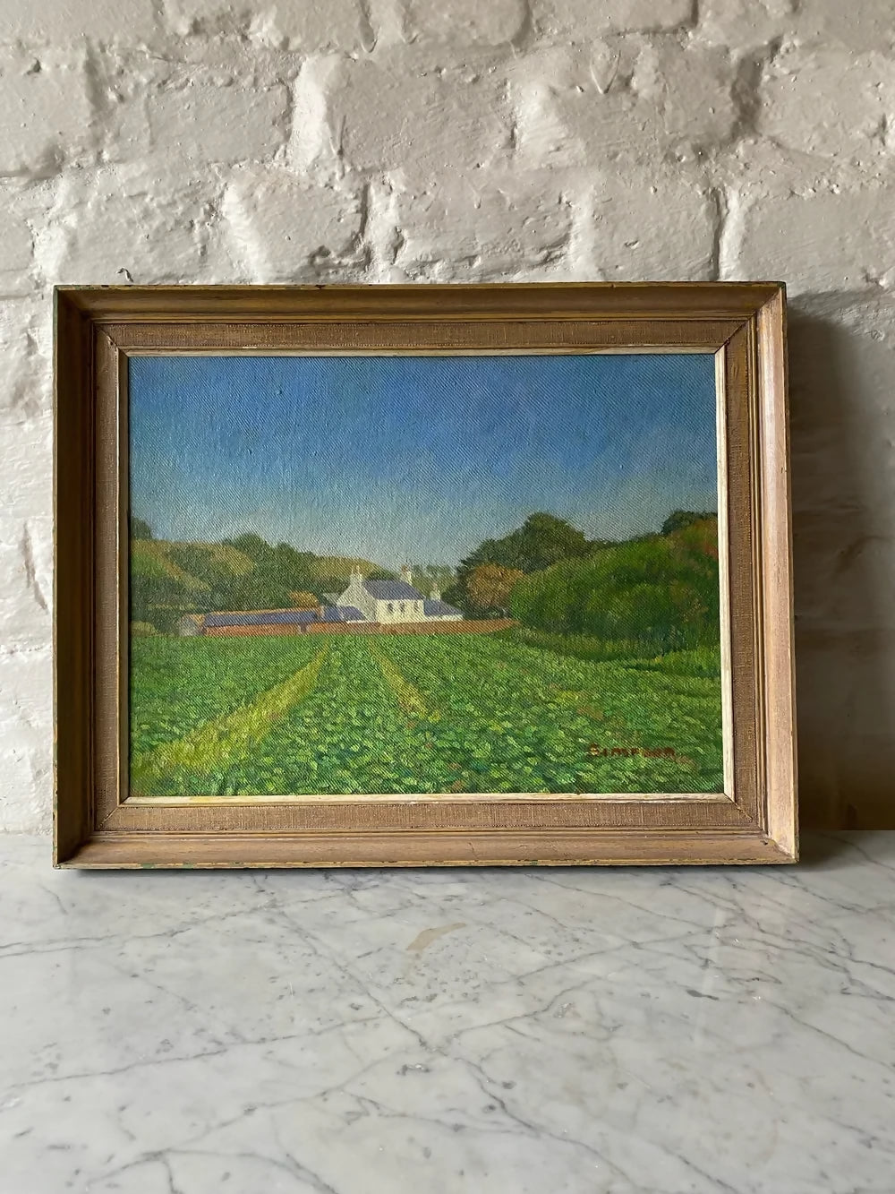 Framed painting of a landscape with a house and fields on a stone wall ,available to buy from the-salon.com. SALON curates the finest unique handmade pieces from the interior industry's best makers and brands. Shop luxury furniture, lighting, rugs, art, antiques and vintage pieces and accessories from SALON interior designed rooms.