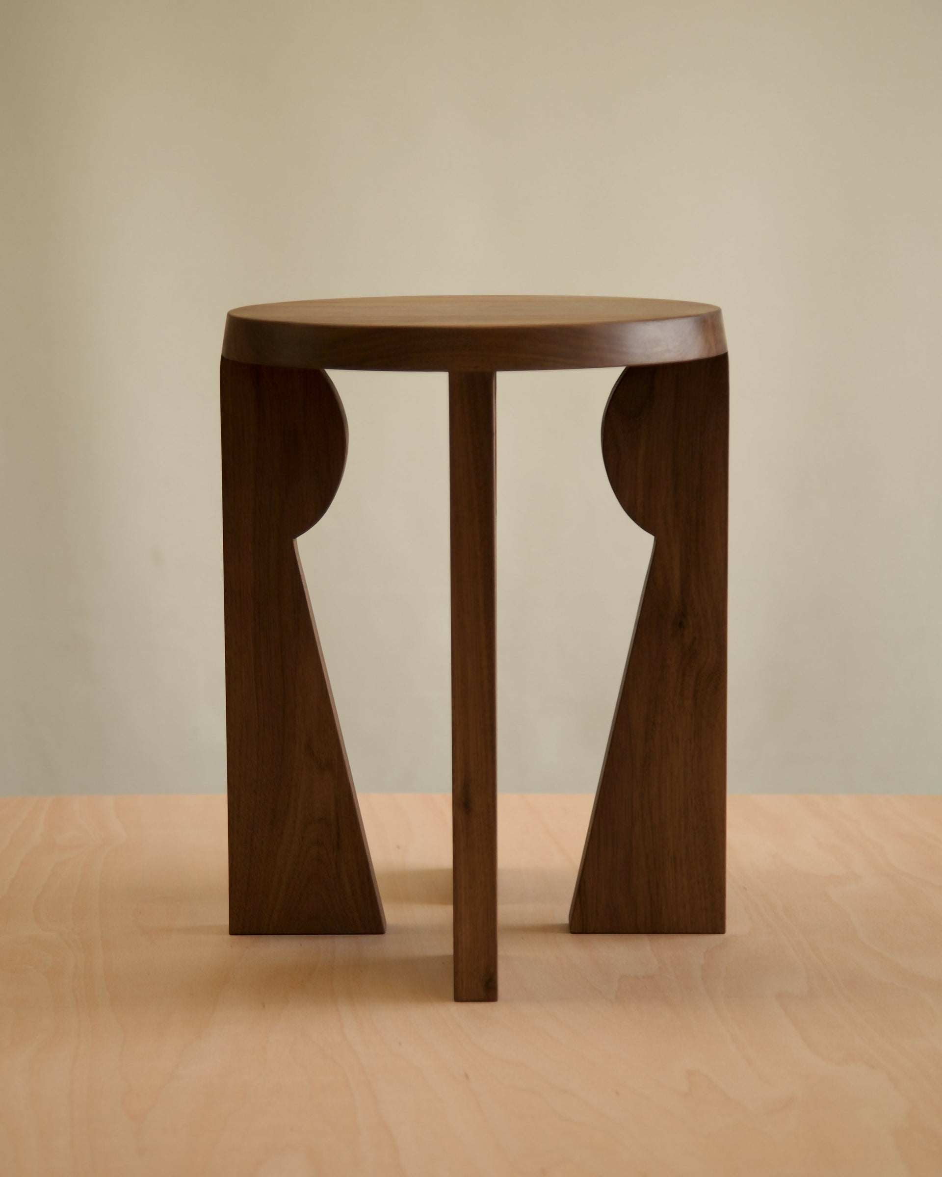 Wooden side table with unique design on a beige background,  available  to buy on the-salon.com. SALON curates the finest , unique, handmade pieces from the interior industry's best makers and brands. Shop luxury furniture, lighting, rugs, art, antiques and vintage pieces and accessories from SALON interior designed rooms.